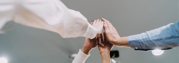 Vier Personen geben sich ein HighFive.