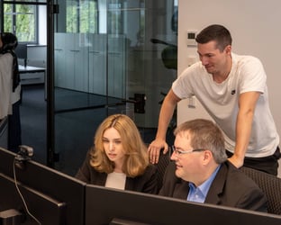 Dual Studierende und Ausbildungsleiter arbeiten gemeinsam an einer Aufgabe.