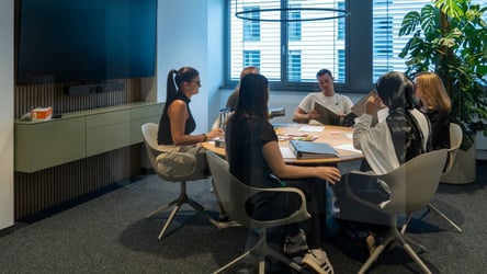 Gruppe von Nachwuchskräften arbeiten gemeinsam im Meetingraum.