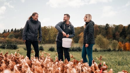 Trainee und Tutorin gemeinsam im Außendienst bei der Beratung auf dem Hof eines Mandanten.