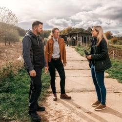 Mitarbeitende sprechen im Außendienst auf einem Hof mit unserem Mandanten