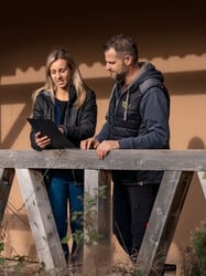 Eine Mitarbeiterin erklärt einem Mandanten etwas im Außendienst.