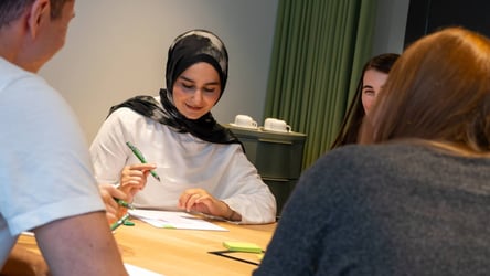 Azubi löst gemeinsam mit anderen Nachwuchskräften eine Aufgabe.