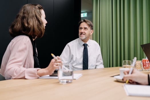 Der Geschäftsführer hat mit Mitarbeitenden ein Meeting.