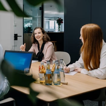 Mitarbeitende sitzen gemeinsam im Meeting.