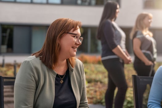 Eine Mitarbeiterin sitzt in der Mittagspause im Außenbereich.