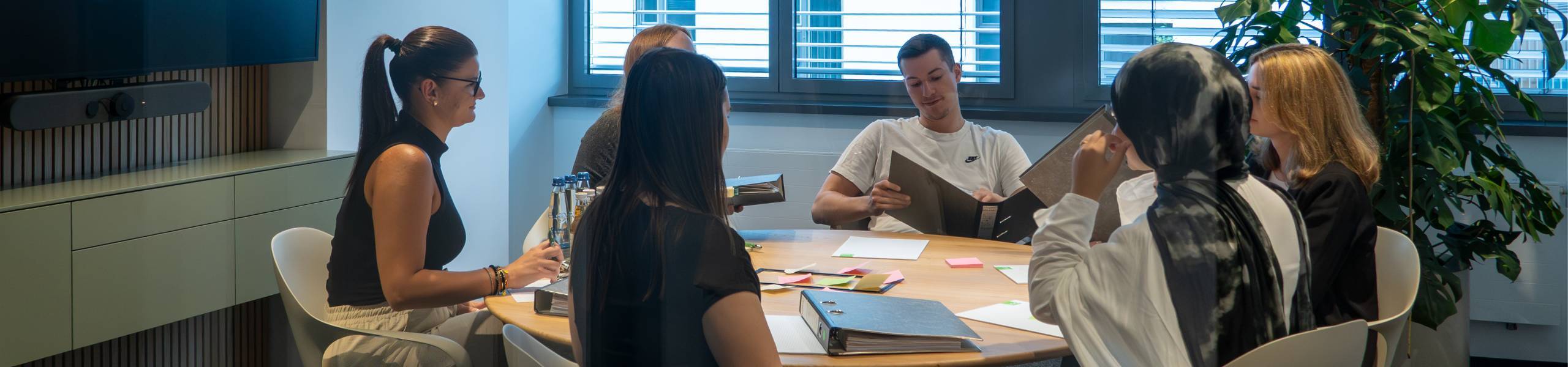Nachwuchskräfte und Auszubildende lernen gemeinsam im Meetingraum..